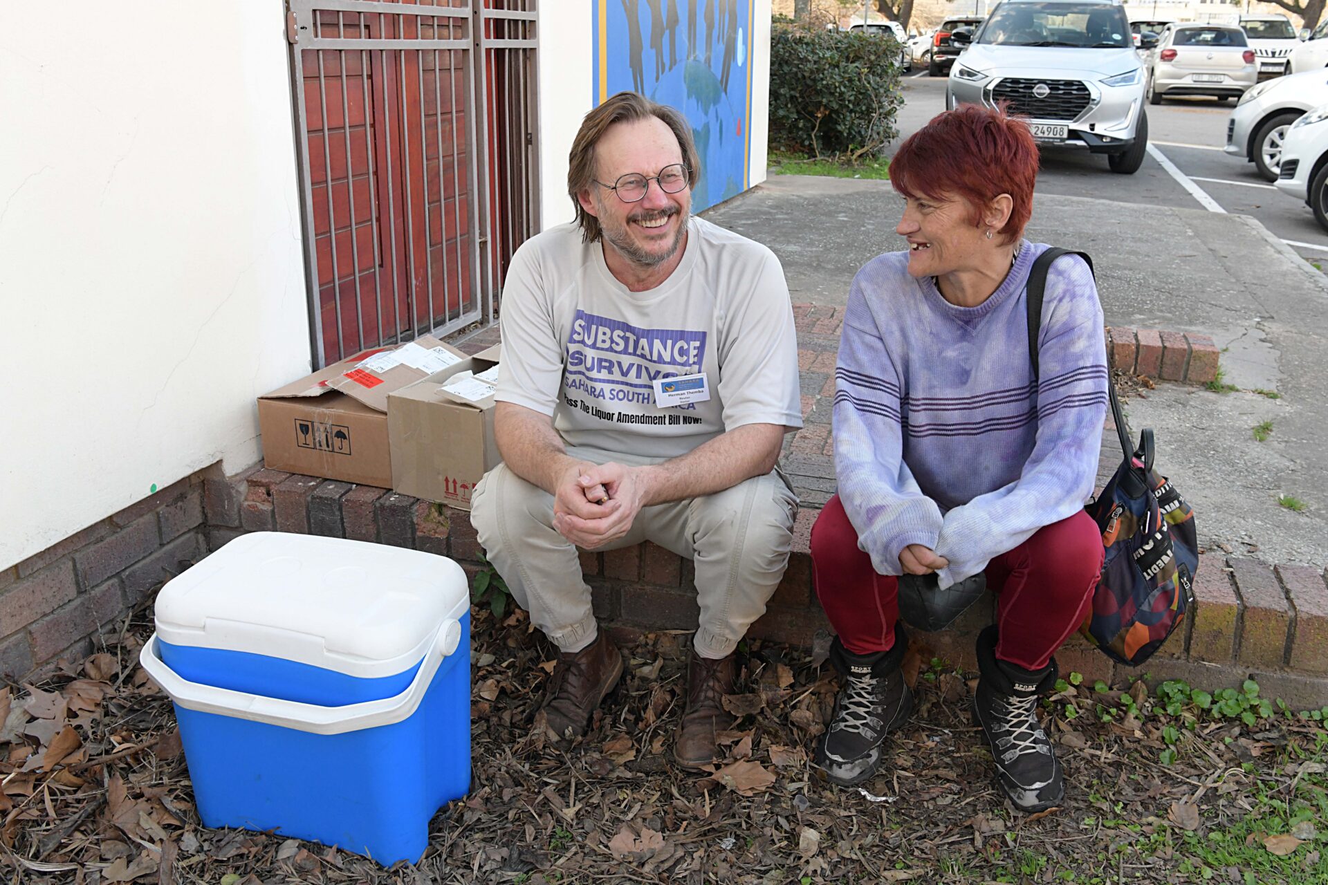 Dr Hermann Reuter and Sarah Lessing sit together outside the central clinic in George.