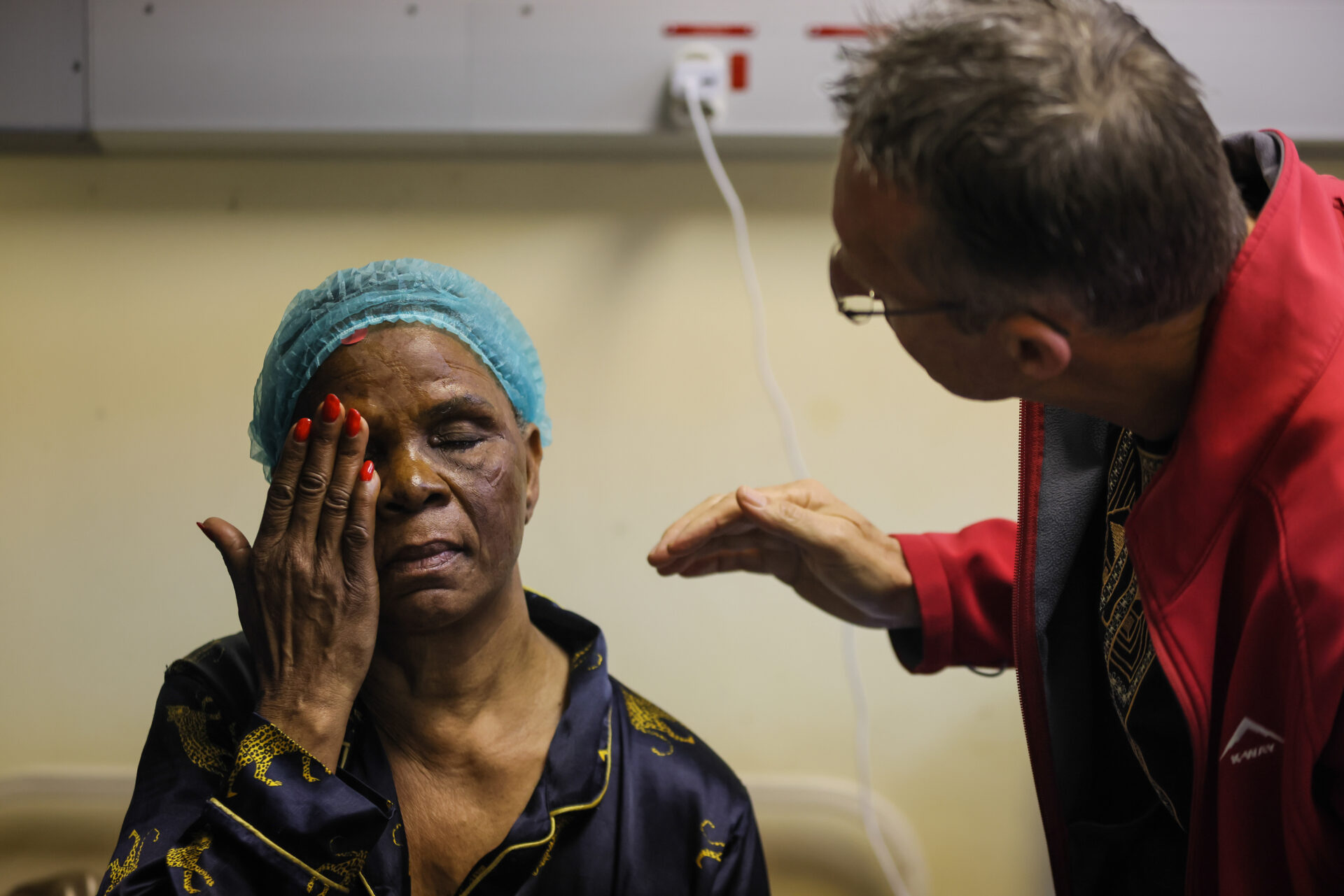 A close-up shot of a woman (Gwedolin Mthethwa) covered her right eye with her hand while Dr Hennie Hamilton check her left eye which was operated on.