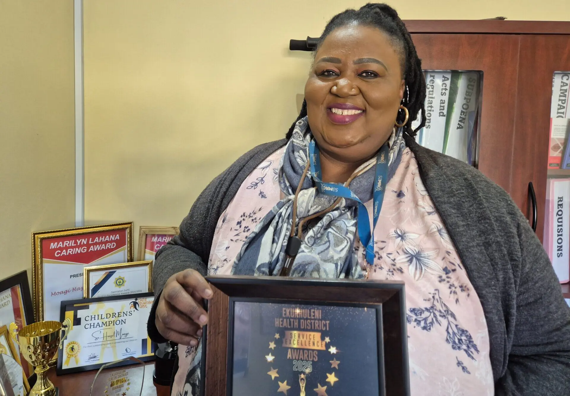 Specialist forensic nurse Hazel Moagi inside her office at Bertha Gxowa Care Centre holding up one of the many certificates she has won.